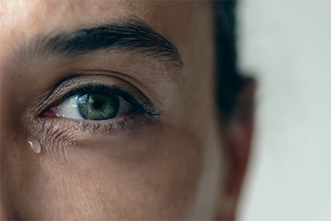 Woman with a tear dropping from her left eye