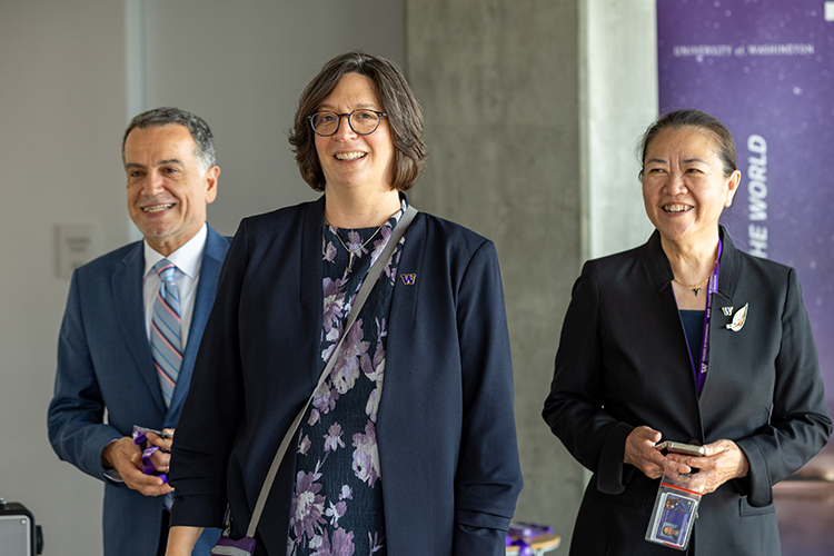 Three people standing and smiling