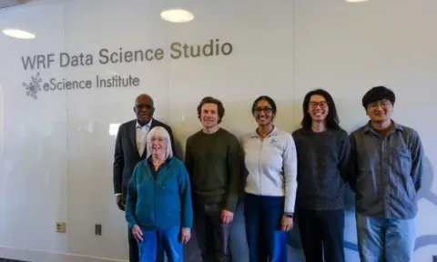 Six people standing against a wall
