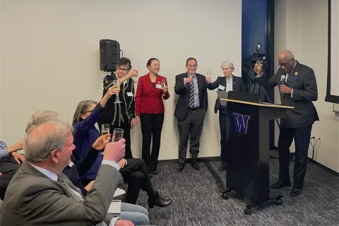 UW leadership standing near a podium